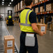 Warehouse worker carrying a JLT tablet in an AgozTech waist belt case while handling a labeled carton.