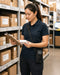 Honeywell shoulder sling holster worn crossbody by a warehouse worker checking inventory with a clipboard and small package.