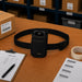 Black Janam waist belt case displayed on a warehouse pick station with a Janam mobile computer, pick list, barcode labels, and packing materials.