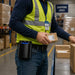 A man with a Honeywell scanner in a belt case is packing in a warehouse