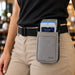 Restaurant employee wearing a gray Agoz myPOS payment terminal holster with an adjustable waist belt for hands-free carrying.