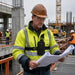 Construction lifestyle: Construction supervisor wearing the Agoz Sonim chest harness while reviewing site plans at an active commercial jobsite.
