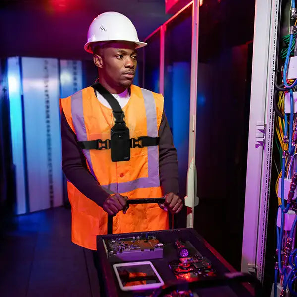 Technician wearing AgozTech chest harness holster with Uniden radio scanner