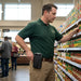 Retail worker using AgozTech holster case with Zebra TC52 & TC52X handheld mobile computer in store aisle